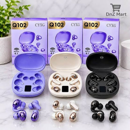 Three pairs of wireless earbuds with their charging cases displayed in front of their retail boxes. The set includes a purple pair, a champagne gold and white pair, and a black pair, all on a light marble surface with a green plant in the background.