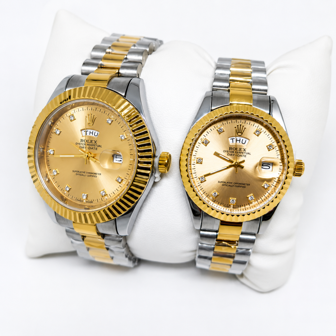 Two Rolex Datejust watches with gold and stainless steel bracelets displayed side by side on a white cushion. The watches feature gold fluted bezels, gold dials with crystal hour markers, and date windows.