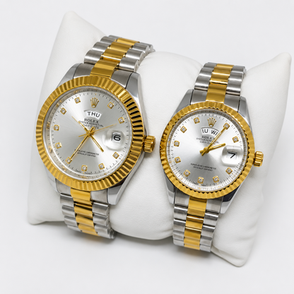 Two Rolex Datejust watches with silver and gold two-tone metal bracelets and white dial faces, displayed on a white cushion against a light gray background.